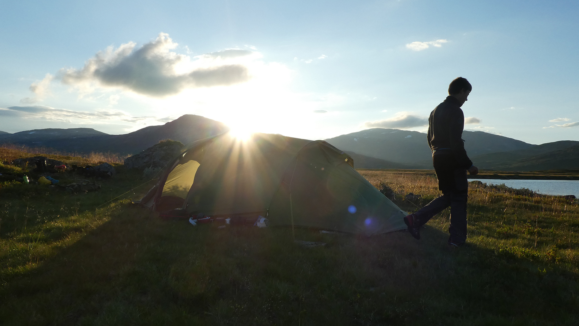 Camping in the mountains sunset, boy on a trip to water